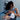 Woman using a hair dryer with a blue towel on a gray background